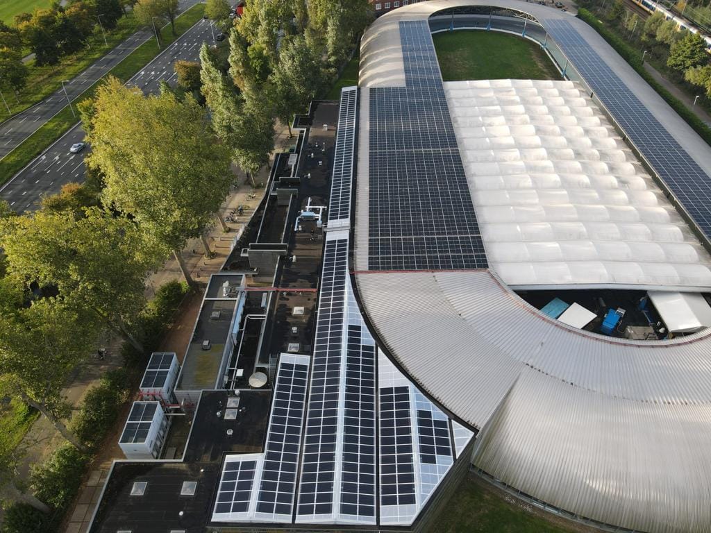 Foto gemaakt met een drone van het dak van de IJsbaan Haarlem waarop 1700 zonnepanelen zijn geplaatst.
